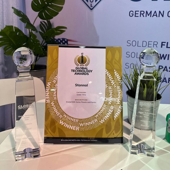 The picture shows a certificate and two glass, cone-shaped awards on a table.